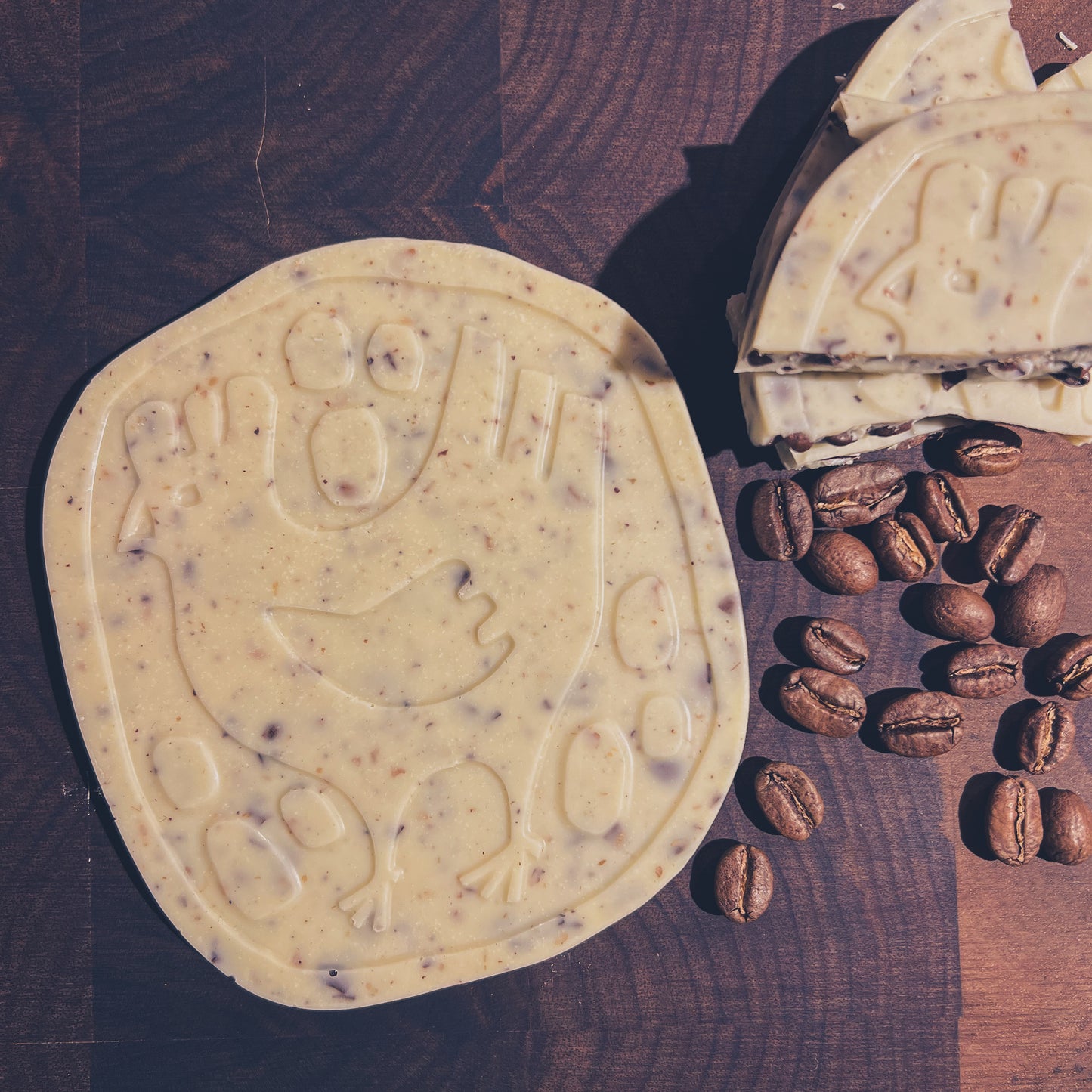 Handcrafted white chocolate with coffee beans, featuring intricate designs, perfect for coffee and chocolate lovers.