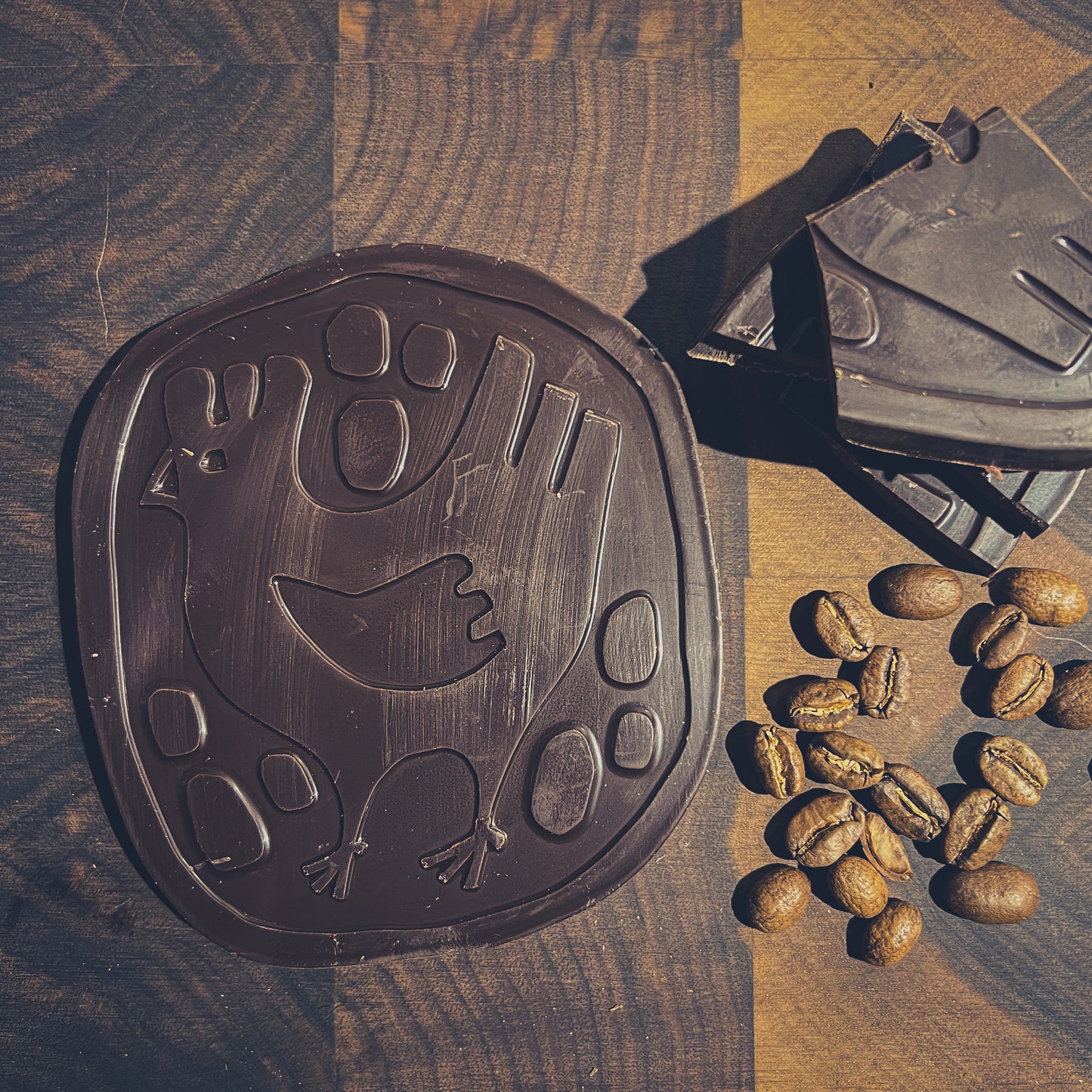 Artisan black chocolate with coffee beans, featuring a unique chicken design, perfect for coffee lovers.