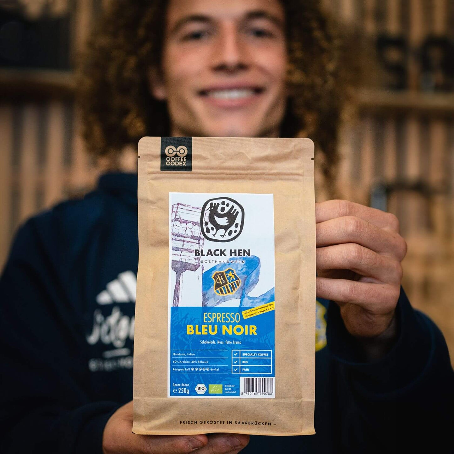 Black Hen Bio Espresso Bleu Noir coffee bag displayed, highlighting its rich chocolate blend from Honduras and India.